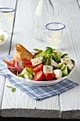 Bowl of Greek salad on checked tablemat