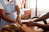 Two masseuse massaging woman at Barberyn Reef Ayurveda Resort in Beruwala, Sri Lanka