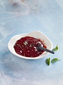 Strawberry jam with mint leaves in bowl