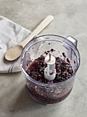Grapes in mixer beside wooden spoon on towel for preparation of jam