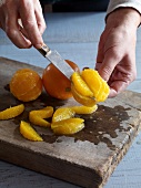 Close-up of removing flesh from oranges with knife for preparation of jam