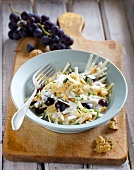 Celery salad with grapes and walnuts in bowl