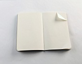 weißes Notizbuch mit Eselsohr, aufgeschlagen