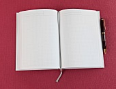 weißes Notizbuch mit Lesebändchen, Kugelschreiber