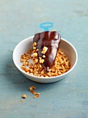 Close-up of chocolate ice pop with almonds in bowl