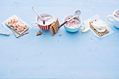 Spreads in cup and crisp breads on blue background