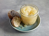 Pineapple jam in small glass with slices of bread on plate