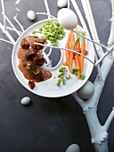 Plate of veal stew with green noodles, breadcrumbs, carrots and eggs on twig