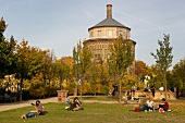 People relaxing in park with building in background at Prenzlauer Berg, Berlin, Germany