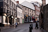 Children walking on street beside facade of buildings in Derry, Ireland