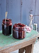 Jars of tart cherry-balsamic jam on a wooden table
