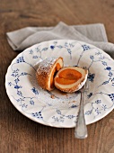 Halved apricot dumplings with powdered sugar on plate