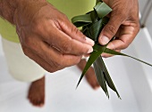 Man holding bird made from palm leaves, Dhigufinolhu island, Maldives