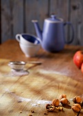 Walnuts, apples, coffee pot and cups on wooden table