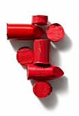 scheibenweise Lippenstifte und Lippenstiftstücke in Rot