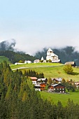 View of houses and La Val church in village Wengen, South Tyrol, Italy