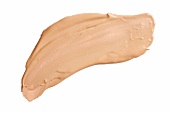 Blob of skin coloured liquid foundation smeared on white background