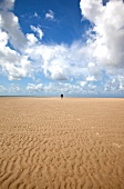 Person walking on the rippled sand at Fano beach, Denmark