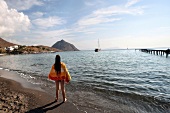 Rear view of woman standing on Karaincir beach, Bodrum, Turkey