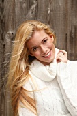 Portrait of beautiful blonde woman with long hair in white turtleneck sweater, smiling