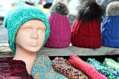 Colourful knitted caps on mannequin and display