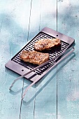 Grilled steaks and coral tongs