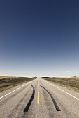 View of empty road with skidmark and landscape on Highway 15, Saskatchewan, Canada