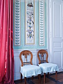 Rustic chairs against wall with ornamental flowers and leaves edgings