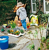 Weekend gardener, little boy playing on terrace in garden