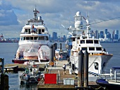 Moored ships at port against cityscape of North Vancouver, British Columbia, Canada