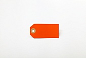 Close-up of orange blank tag on white background