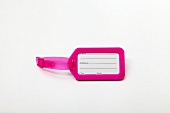 Close-up of pink luggage tag on white background