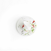 Floral pattern cup and saucer on white background