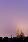 View of town hall towers of St. Mary Church in fog at Lubeck, Schleswig Holstein, Germany