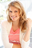 Portrait of attractive blonde woman wearing bright jacket over pink top, smiling