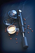 Handpresso with cup of coffee and coffee beans