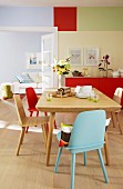 Colourful dining room with view into living room painted pale blue