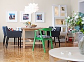 Dining room with dining table, chair, chandelier and picture frames on wall