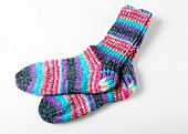 Multi-coloured knit woollen socks on white background