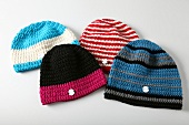 Four colourful knitted hats on white background