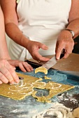 Person cutting moon shaped cookies with cutter