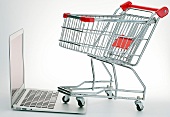 Einkaufswagen steht auf MacBook Air Symbol Online Shopping