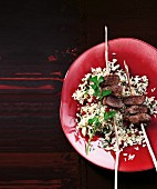 Pomegranate pilau with lamb skewers