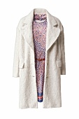 Woolen coat over patterned dress against white background
