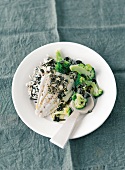Fish with broccoli, pumpkin seeds and rice on plate