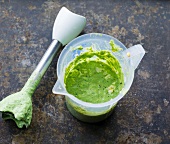 Overhead view of green yogurt sauce in plastic mug