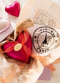 Close-up of travel vouchers, map and heart shaped travel box with ribbon