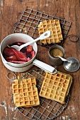 Waffles on grill with cassis and marzipan poached pear in saucepan