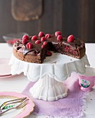 Crunchy chocolate cake with raspberries, sliced