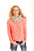 Portrait of pretty blonde woman wearing apricot colour sweater and scarf, smiling